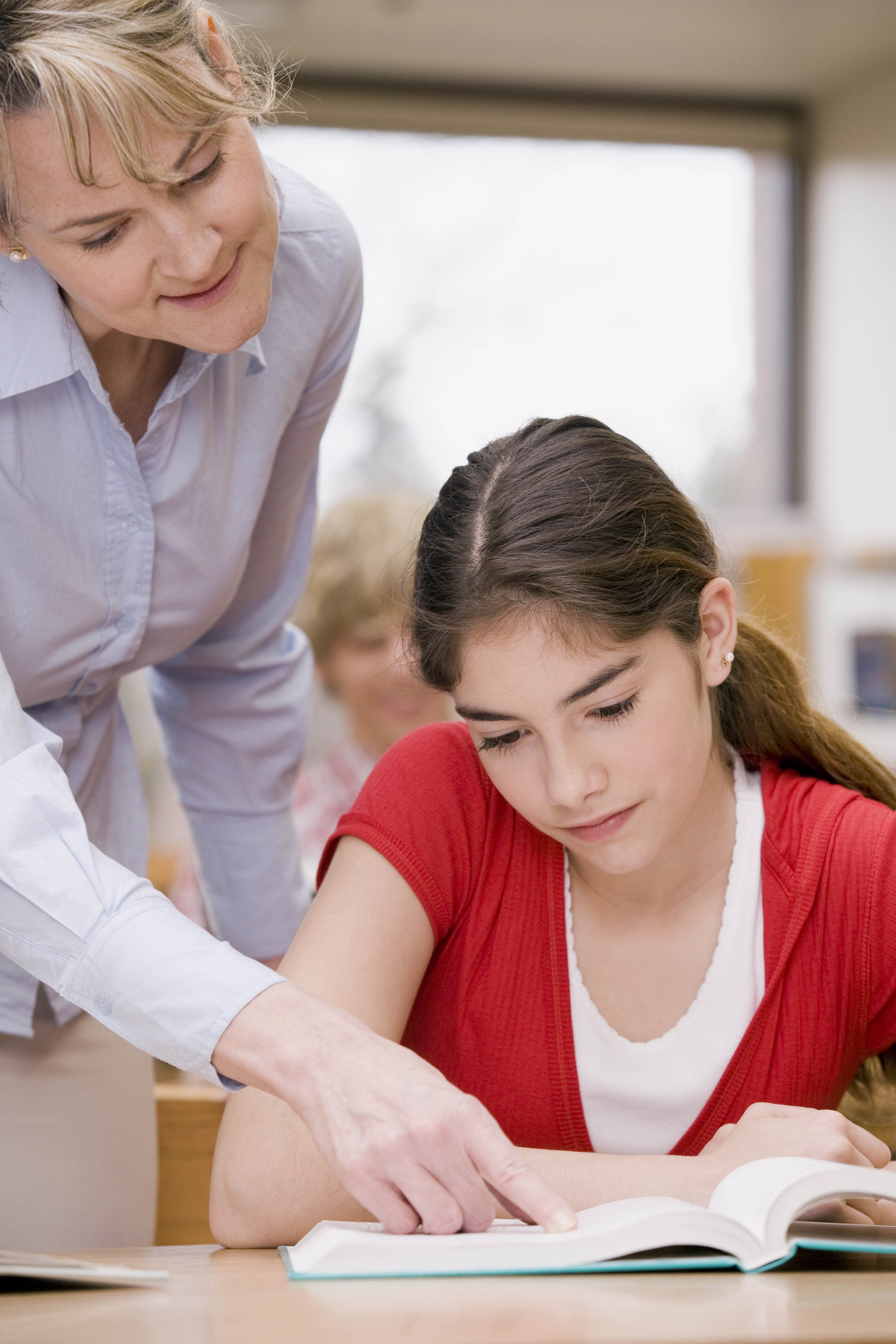 Teacher pointing on a girl's book